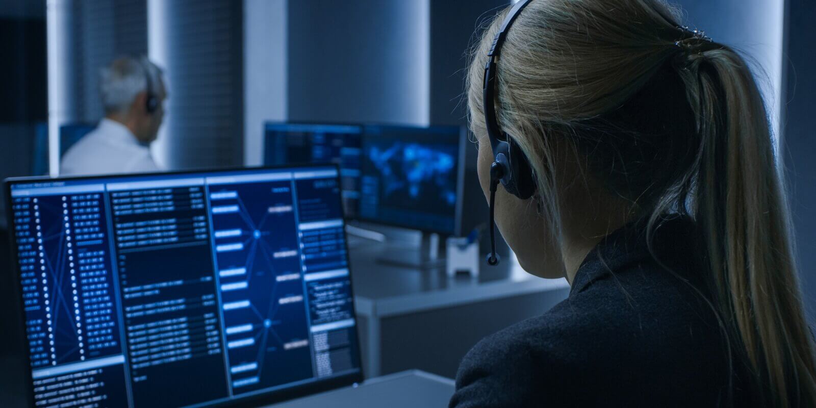 female controller wearing headset working on personal computer and monitoring siecial Intelligence systems