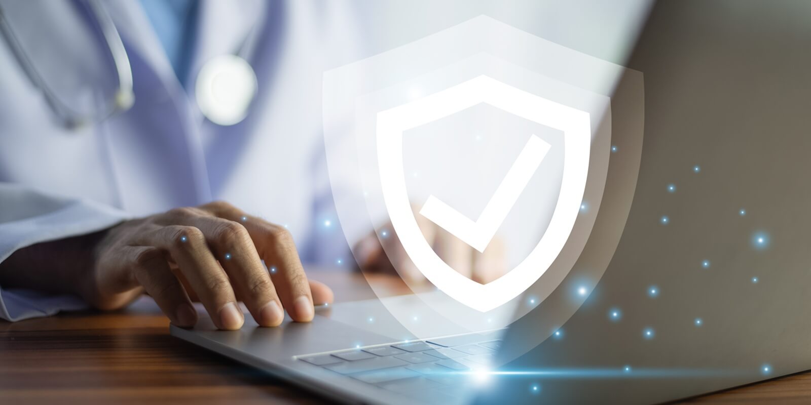 doctor typing on a laptop with a glowing shield icon