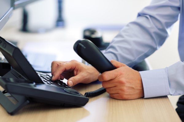 Businessman Using His VoIP Phone System That Was Seamlessly Integrated With His Existing Infrastructure