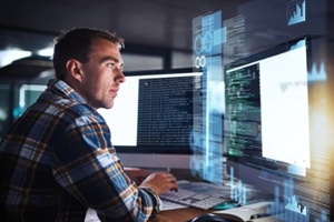 man and programmer code on computer screen with SIEM cybersecurity hologram