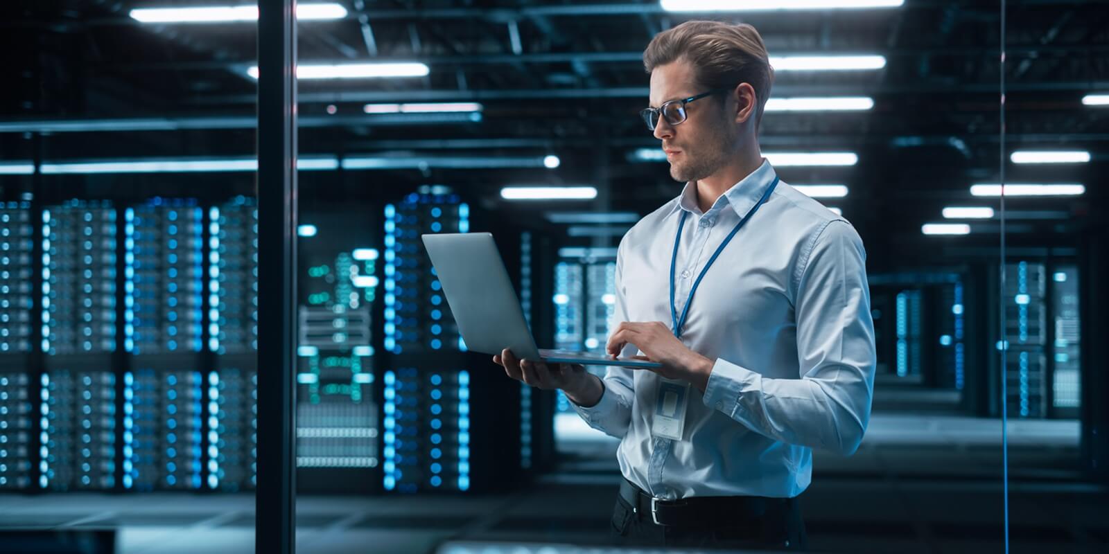 portrait of it specialist uses laptop in data center