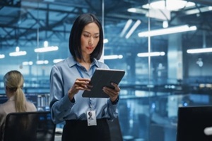 beautiful asian female cybersecurity expert works on her tablet computer in a modern facility