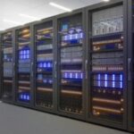 Rows of enterprise data center server racks with blue LED lighting, representing secure data backup infrastructure for business