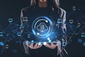 woman holding tablet with glowing cloud storage hologram and connected devices representing online data network and internet backup concept