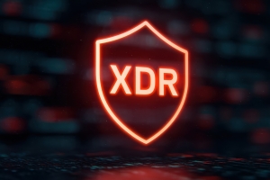 Glowing orange XDR shield icon against a dark digital background representing Extended Detection and Response cybersecurity protection