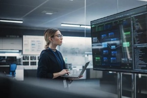 female expert using laptop computer, collaborating with developers online
