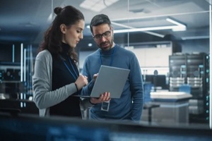 two engineers using laptop computer to analyze and discuss about artificial intelligence software