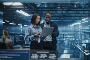 male DevOps engineer and female IT consultant work on a laptop