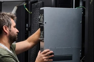 it technician installing server hardware in a data center during routine maintenance and system upgrade