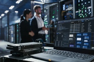 laptop sits on a cart beside hard drives in data center
