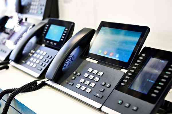 row of office phones on a desk
