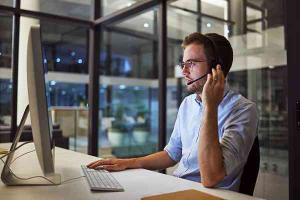 young support professional talking on the phone at a desk